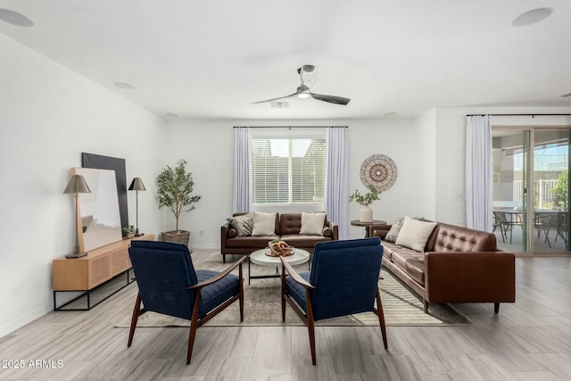 living room with light wood-type flooring and ceiling fan