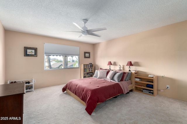 carpeted bedroom featuring a ceiling fan and a textured ceiling