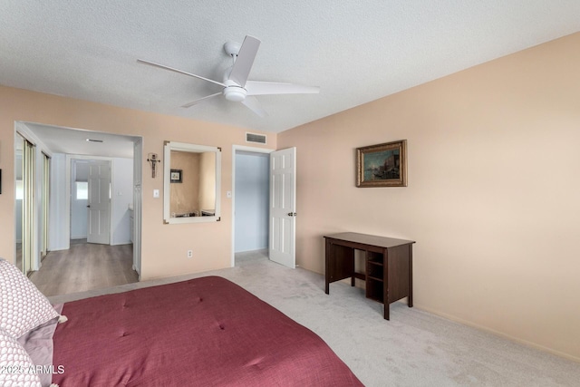 bedroom with ceiling fan, carpet, visible vents, and a textured ceiling
