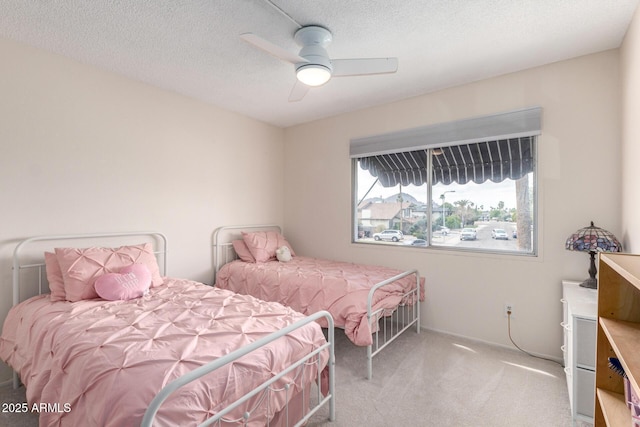 bedroom with a ceiling fan, carpet, and a textured ceiling