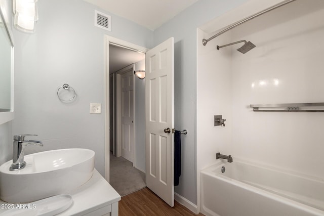bathroom featuring tub / shower combination, vanity, wood finished floors, and visible vents