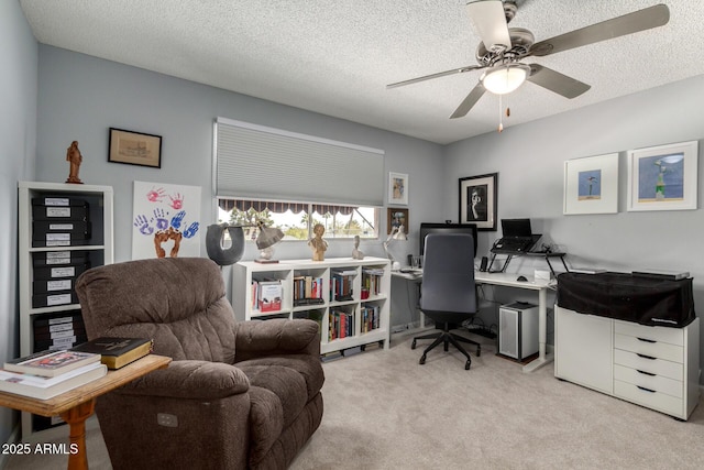 office area featuring ceiling fan, a textured ceiling, and light carpet