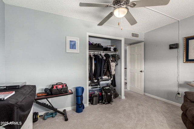 interior space featuring a ceiling fan, baseboards, visible vents, a textured ceiling, and carpet flooring