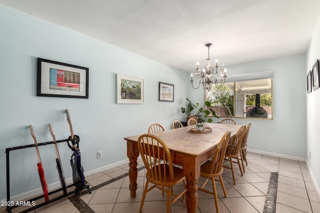 dining space with light tile patterned floors, baseboards, and a notable chandelier