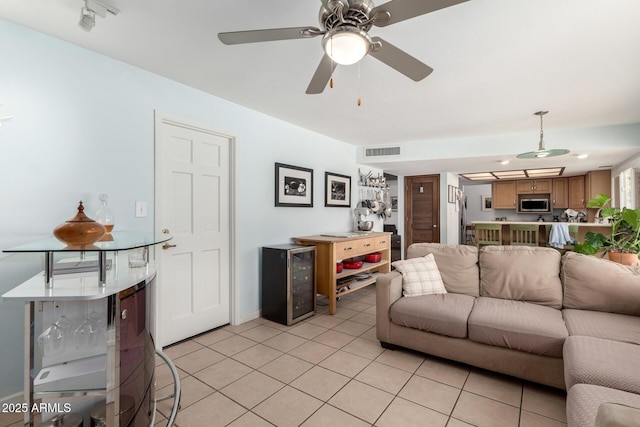 living area featuring light tile patterned floors, visible vents, wine cooler, and ceiling fan