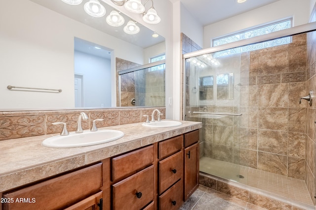 full bathroom with double vanity, a shower stall, and a sink