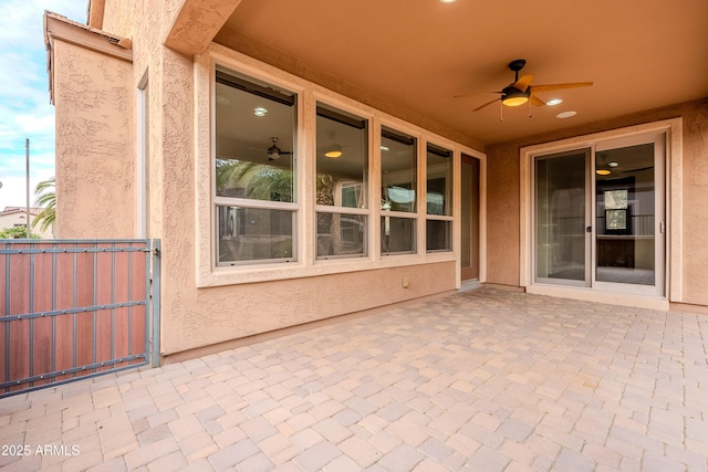 view of patio with a ceiling fan, fence, and a gate