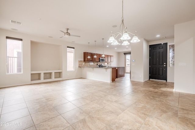 unfurnished living room featuring visible vents, light tile patterned floors, baseboards, ceiling fan with notable chandelier, and recessed lighting