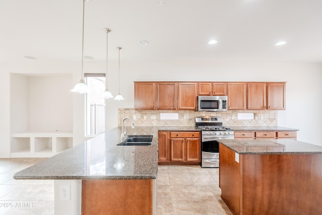 kitchen with decorative backsplash, brown cabinets, a sink, dark stone counters, and stainless steel appliances