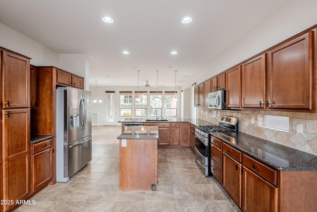 kitchen featuring appliances with stainless steel finishes, tasteful backsplash, a sink, a peninsula, and recessed lighting