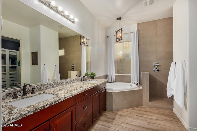 bathroom featuring vanity and a relaxing tiled tub