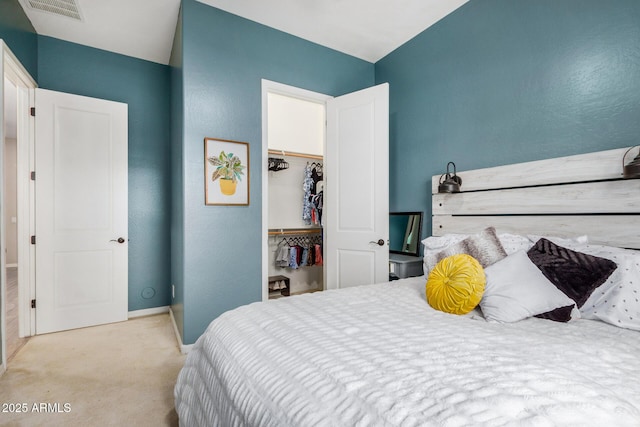 bedroom featuring light carpet, a closet, and a spacious closet