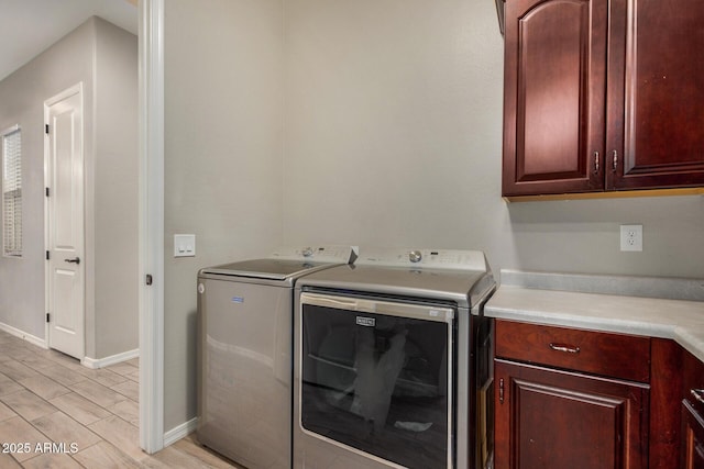 laundry room with cabinets, independent washer and dryer, and light hardwood / wood-style floors