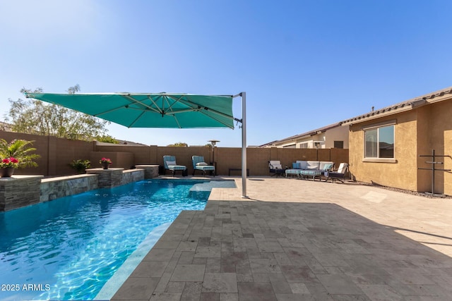 view of pool featuring outdoor lounge area, pool water feature, and a patio area