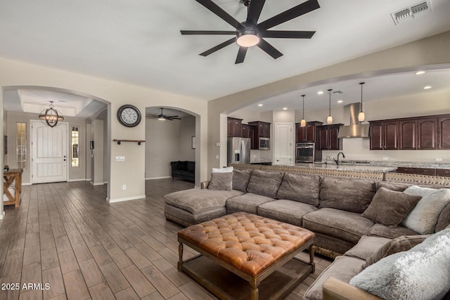 living room with ceiling fan with notable chandelier