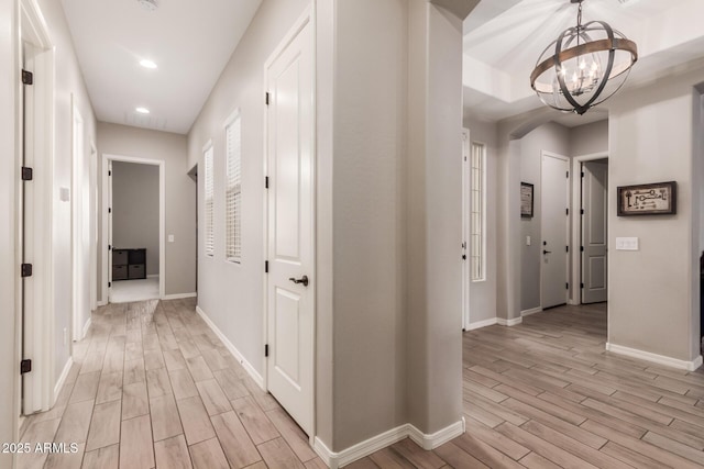 hallway with a chandelier and light hardwood / wood-style flooring