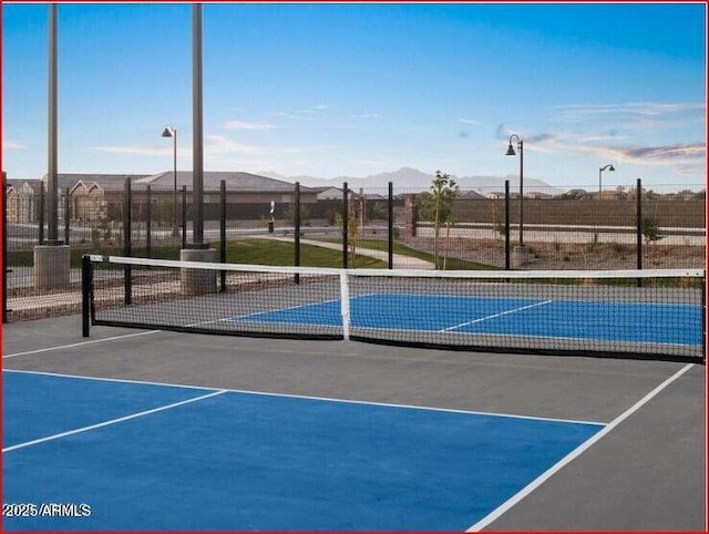 view of basketball court with community basketball court, fence, a tennis court, and a mountain view