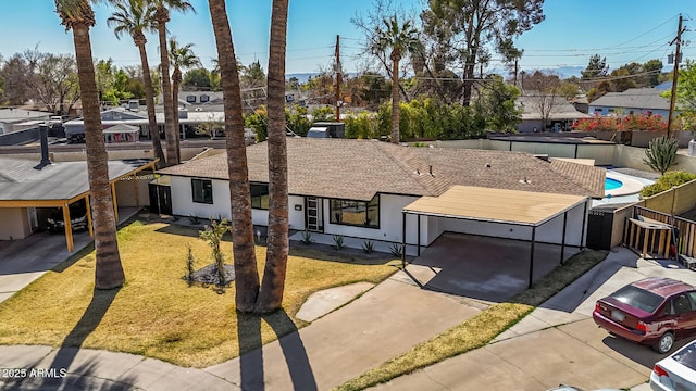 view of front of house with a front lawn, fence, a residential view, and stucco siding