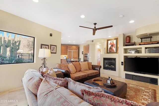 living room with recessed lighting, visible vents, a glass covered fireplace, light tile patterned flooring, and ceiling fan