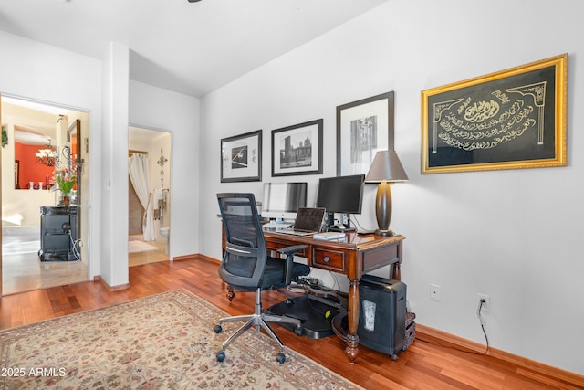 office featuring a chandelier, wood finished floors, and baseboards