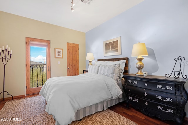 bedroom with dark hardwood / wood-style floors and access to outside