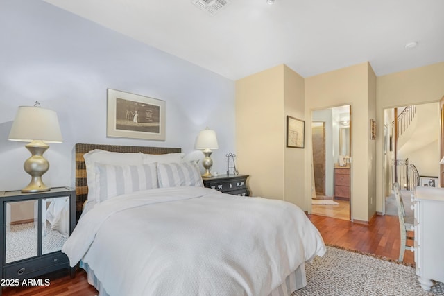 bedroom with wood-type flooring and connected bathroom