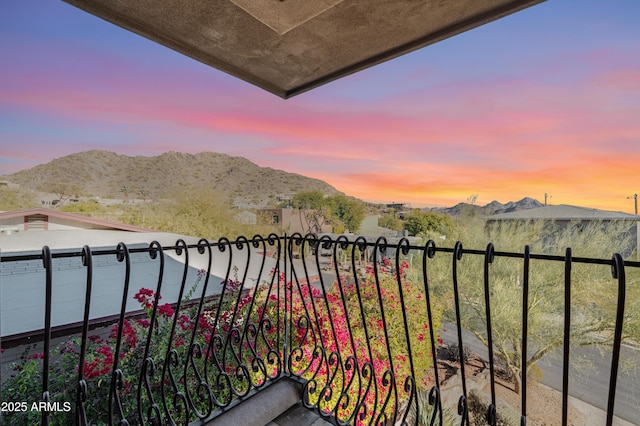 balcony at dusk featuring a mountain view