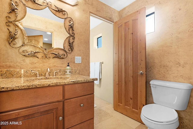 bathroom featuring toilet, vanity, and tile patterned flooring