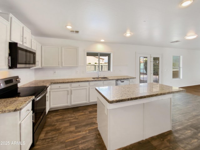 kitchen with a kitchen island, white cabinetry, stainless steel appliances, and dark wood-style flooring