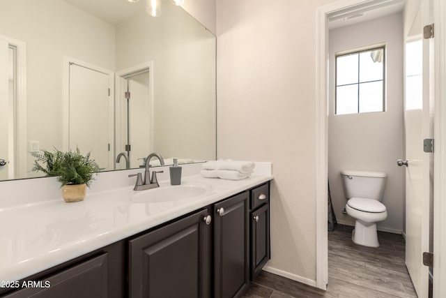 bathroom with vanity, hardwood / wood-style flooring, and toilet