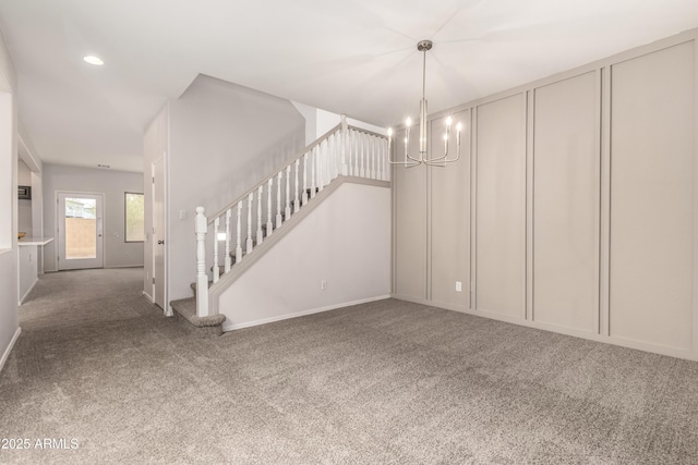 unfurnished living room featuring a chandelier and carpet flooring