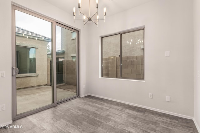 unfurnished room featuring wood-type flooring and a chandelier