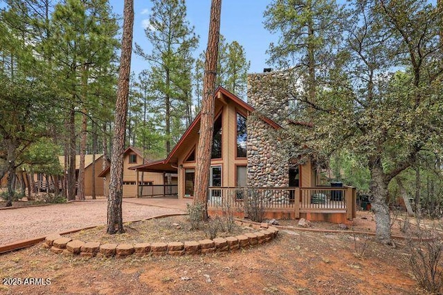 rear view of property featuring a deck and a chimney