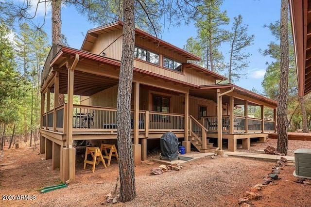 rear view of house featuring a wooden deck and a sunroom