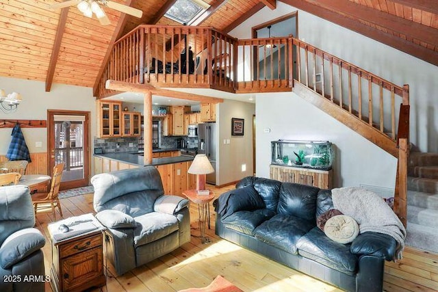 living area featuring wood ceiling, light wood finished floors, stairway, and beam ceiling