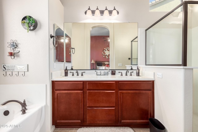 full bathroom with a sink, a garden tub, a stall shower, and double vanity