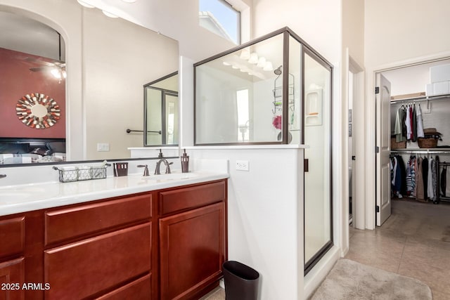 full bathroom featuring a spacious closet, a shower stall, tile patterned floors, and vanity