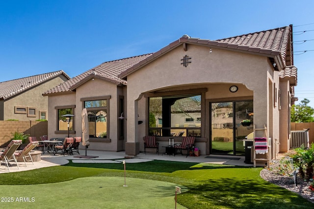 back of house featuring stucco siding, a tile roof, a patio, and fence