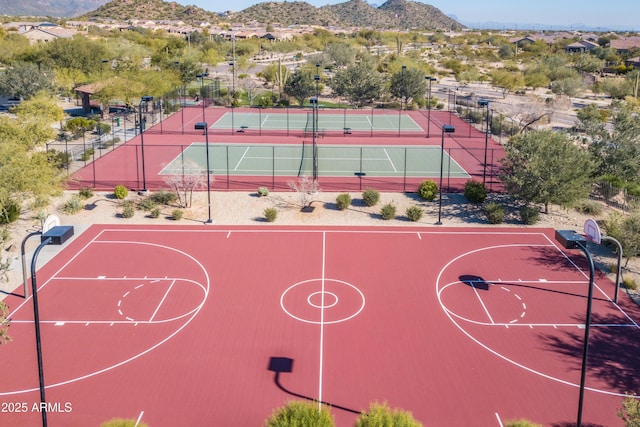 view of basketball court featuring a mountain view and fence