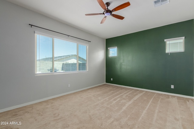 carpeted spare room featuring ceiling fan