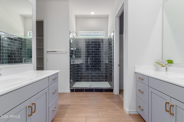 bathroom featuring a tile shower and vanity with extensive cabinet space