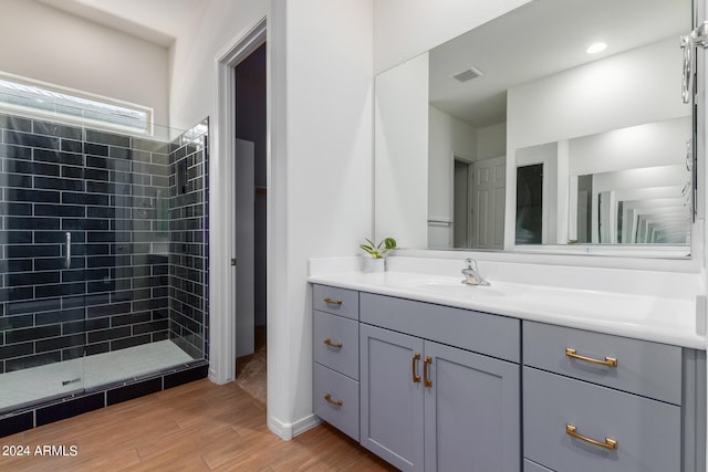 bathroom featuring a tile shower and vanity with extensive cabinet space