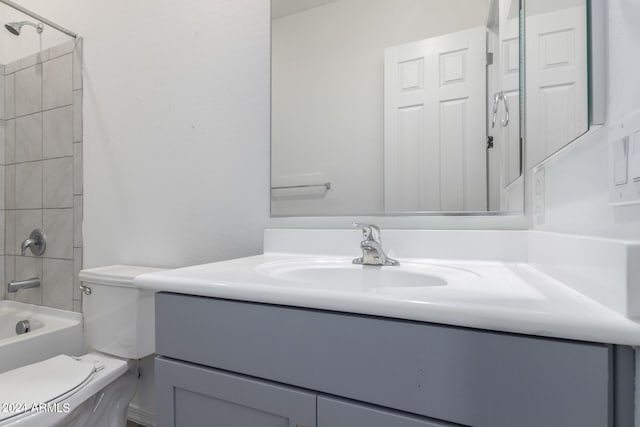 full bathroom with tiled shower / bath, oversized vanity, and toilet