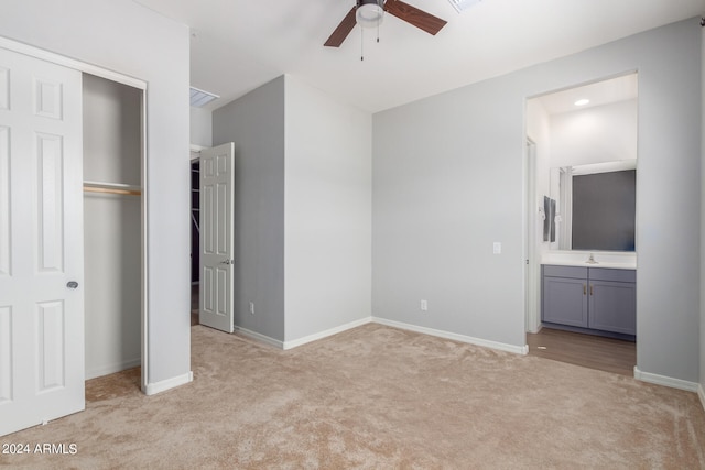 unfurnished bedroom with connected bathroom, a closet, ceiling fan, and light colored carpet