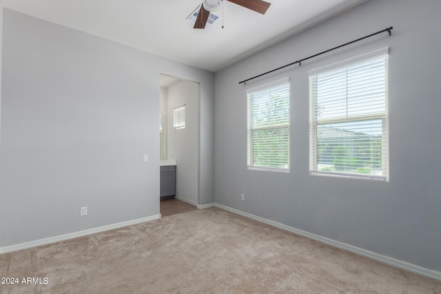 carpeted spare room with a healthy amount of sunlight and ceiling fan