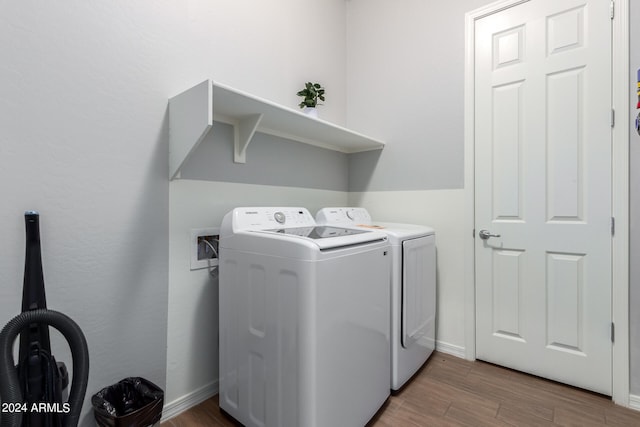 clothes washing area featuring separate washer and dryer, washer hookup, and hardwood / wood-style flooring