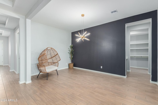 sitting room featuring an inviting chandelier and light wood-type flooring