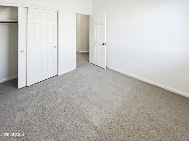 unfurnished bedroom with carpet, baseboards, and a closet