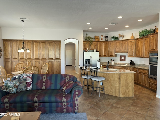 4116 E Sierra Sunset Trl, Cave Creek, AZ 85331 - kitchen with appliances with stainless steel finishes, open floor plan, arched walkways, and pendant lighting