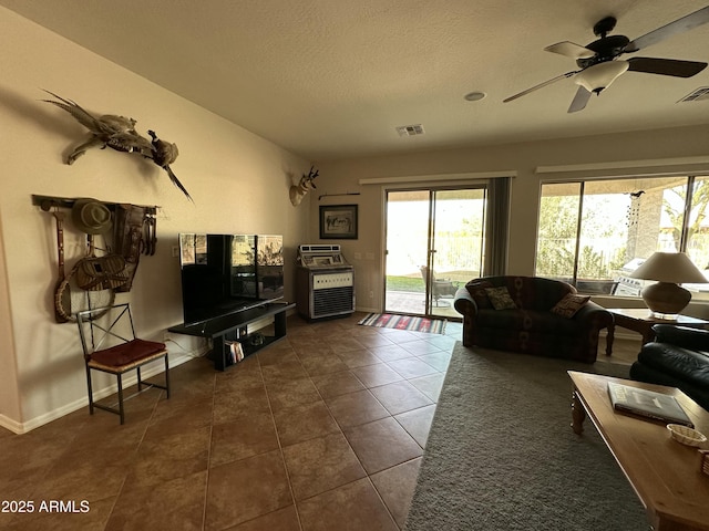 4116 E Sierra Sunset Trl, Cave Creek, AZ 85331 - living room featuring baseboards, visible vents, a textured ceiling, and dark tile patterned flooring